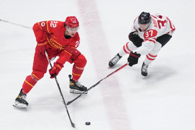 2月13日,在国度体育馆举行的北京2022年冬奥会须眉冰球小组赛中,中国队迎战加拿大队。图为来自昆仑鸿星冰球俱乐部的中国队球员福帅(左)在比赛中。新华社记者杜宇摄